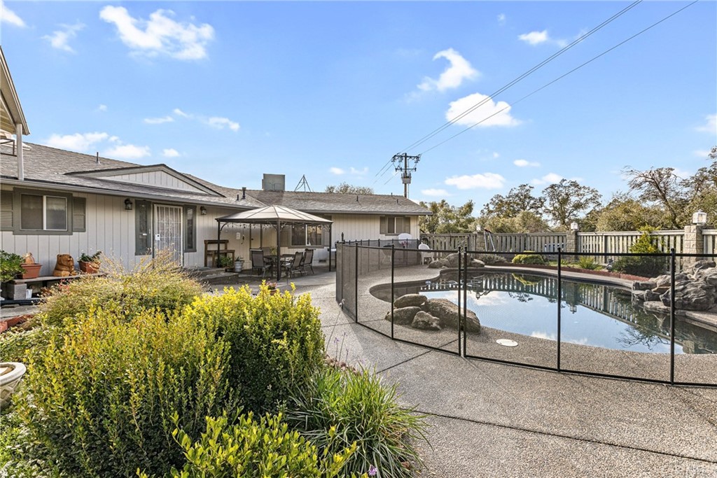 45943 Black Oak Road Coarsegold, CA 93614 - Photo 9 of 64 a view of a white house with swimming pool lawn chairs and couches