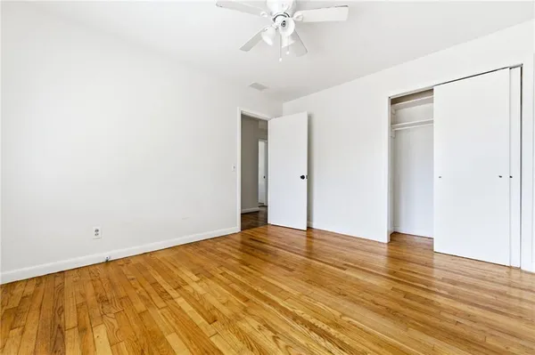 a view of an empty room with wooden floor