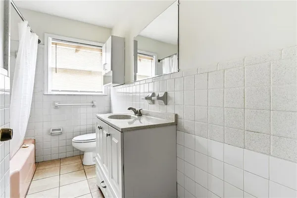 a bathroom with a granite countertop sink a toilet and a mirror