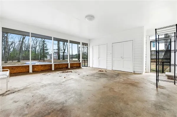 an empty room with sliding glass door and floor to ceiling window