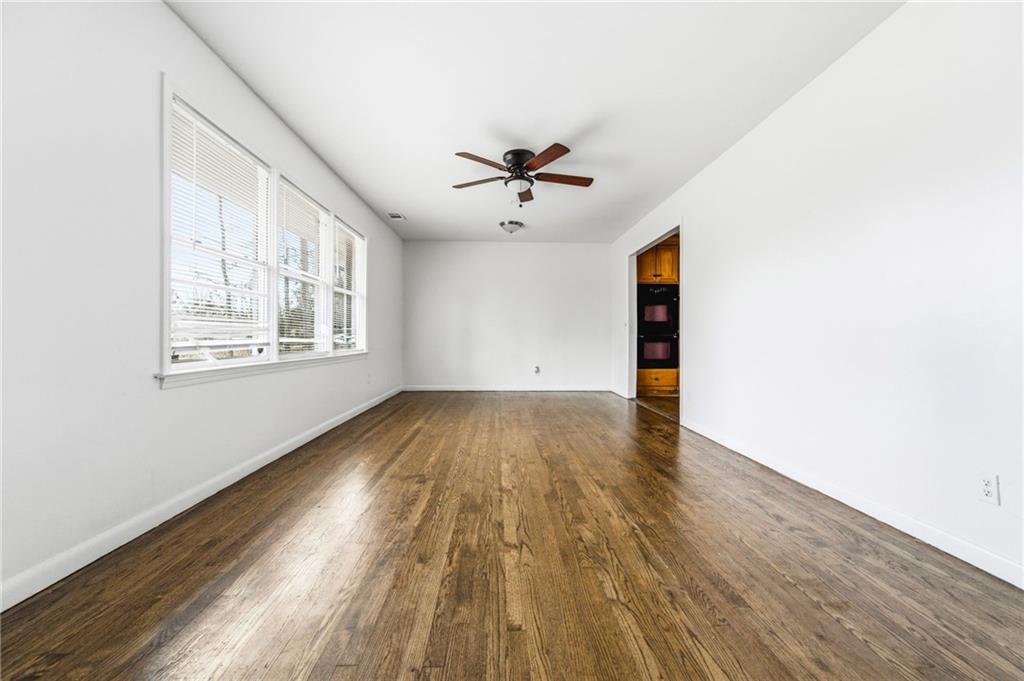 45 Chaffin Road Roswell, GA 30075 - Photo 4 of 26 an empty room with wooden floor chandelier fan and windows