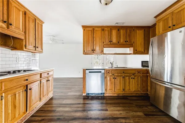 a kitchen with stainless steel appliances granite countertop a refrigerator stove and sink