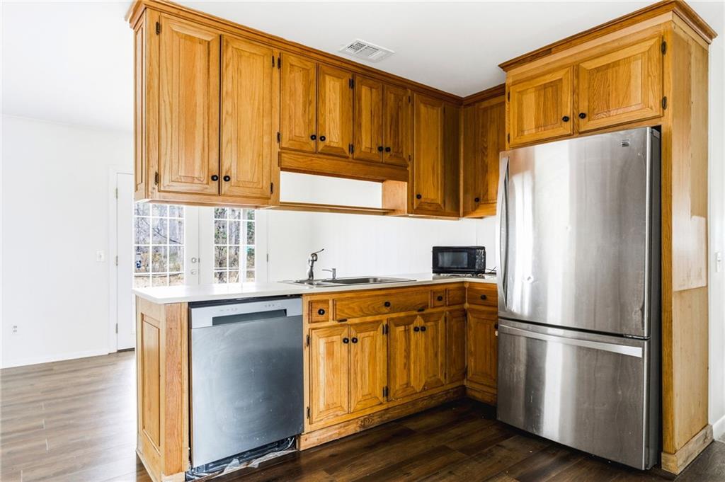 45 Chaffin Road Roswell, GA 30075 - Photo 8 of 26 a kitchen with stainless steel appliances granite countertop a refrigerator a sink and dishwasher with wooden floor