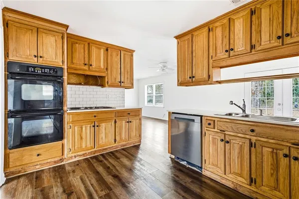 a kitchen with granite countertop wooden cabinets a sink and dishwasher