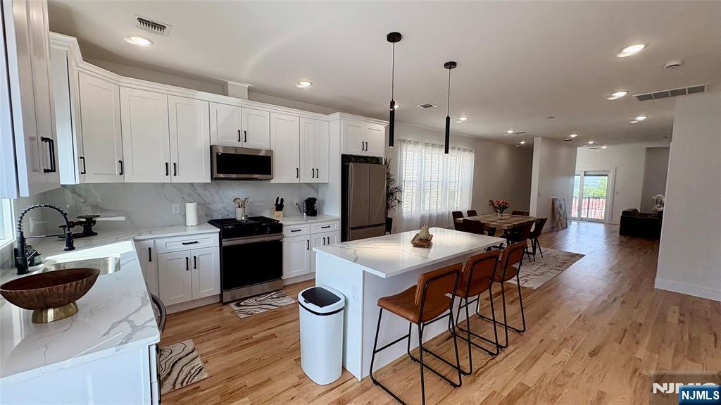 367 Devon Street, Unit 2 Kearny, NJ 07032 - Photo 9 of 30 a kitchen with a dining table chairs and a refrigerator