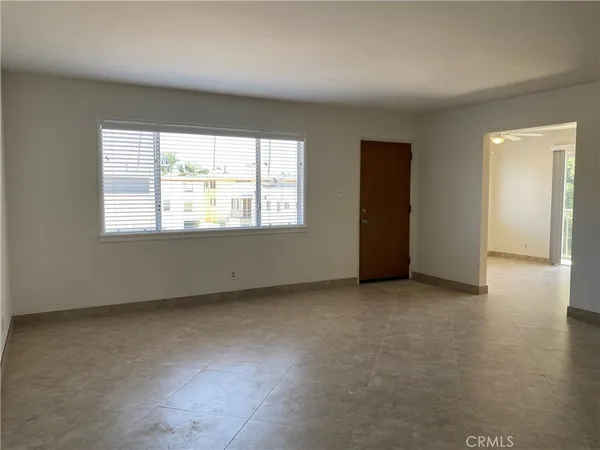 an empty room with a window and a ceiling fan