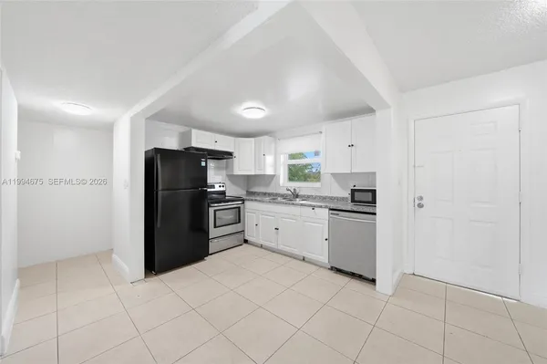 a kitchen with granite countertop stainless steel appliances and white cabinets