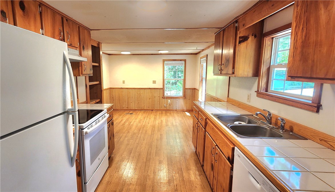 Rich wood cabinetry and classic tile countertops define this functional kitchen space.
