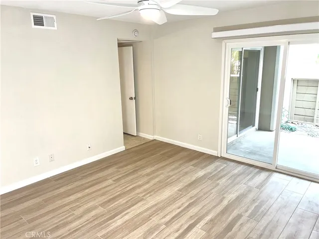 an empty room with wooden floor and door