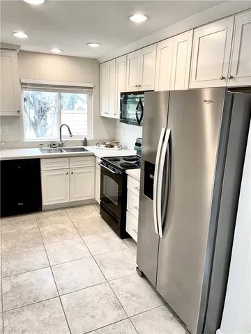 a kitchen with stainless steel appliances granite countertop a refrigerator sink and stove