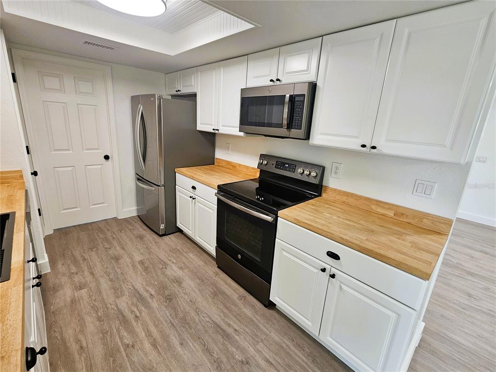 12218 Shadow Ridge Boulevard Hudson, FL 34669 - Photo 11 of 34 a kitchen with a stove a refrigerator and a sink