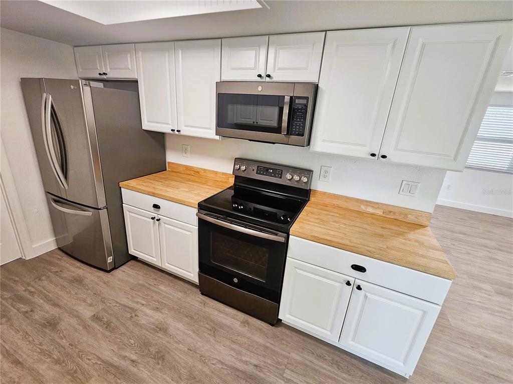 12218 Shadow Ridge Boulevard Hudson, FL 34669 - Photo 12 of 34 a kitchen with stainless steel appliances a stove microwave and refrigerator