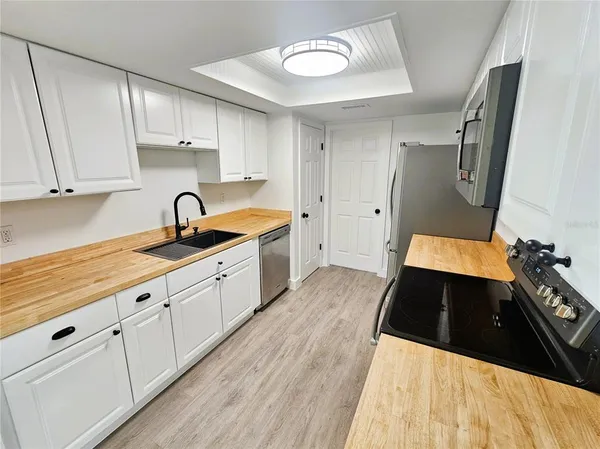 a kitchen with granite countertop white cabinets and a sink