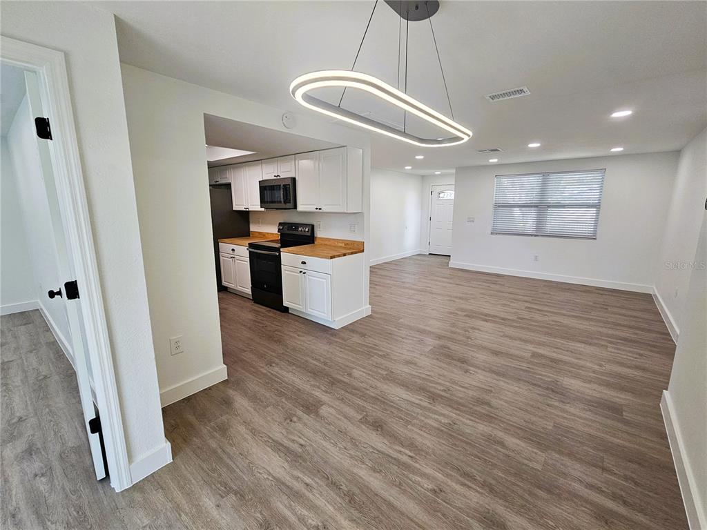 12218 Shadow Ridge Boulevard Hudson, FL 34669 - Photo 16 of 34 a view of a kitchen with a sink and dishwasher a refrigerator with wooden floor