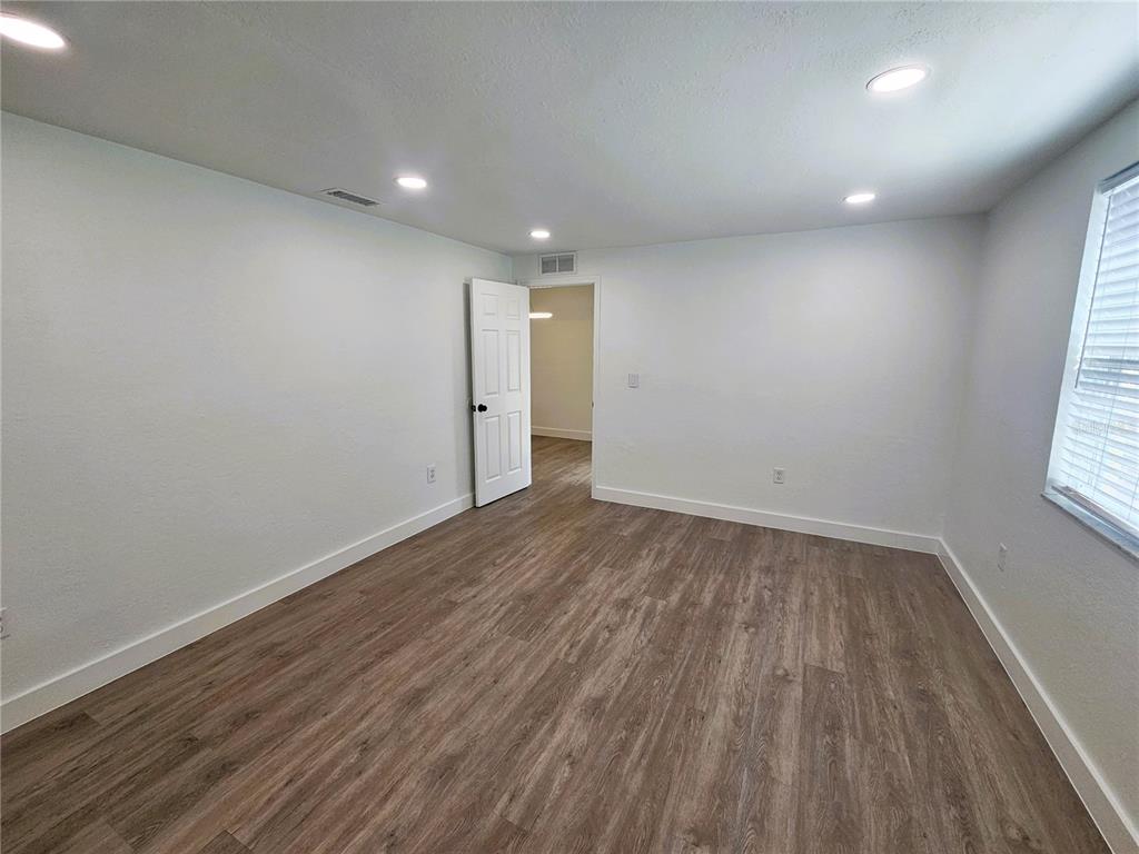 12218 Shadow Ridge Boulevard Hudson, FL 34669 - Photo 17 of 34 wooden floor in an empty room with a window