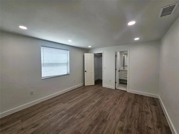 a view of a hallway with wooden floor and closet