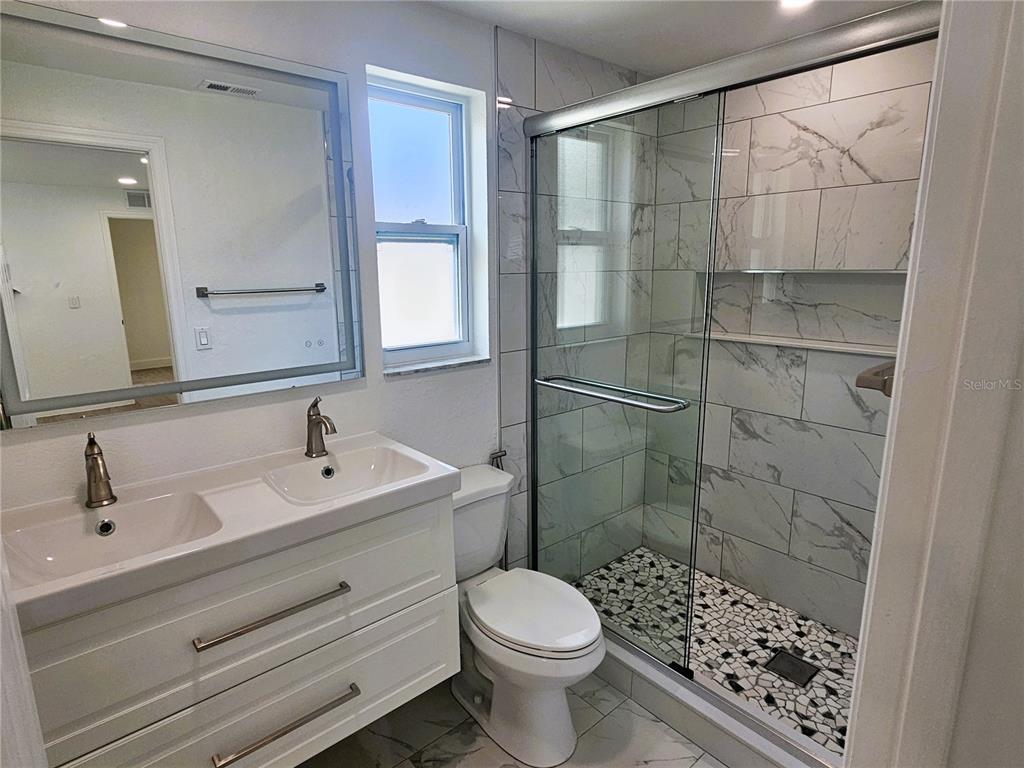12218 Shadow Ridge Boulevard Hudson, FL 34669 - Photo 20 of 34 a bathroom with a sink toilet and shower