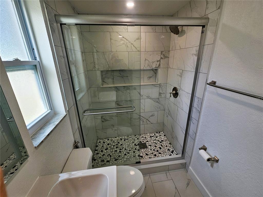 12218 Shadow Ridge Boulevard Hudson, FL 34669 - Photo 21 of 34 a bathroom with a shower and toilet