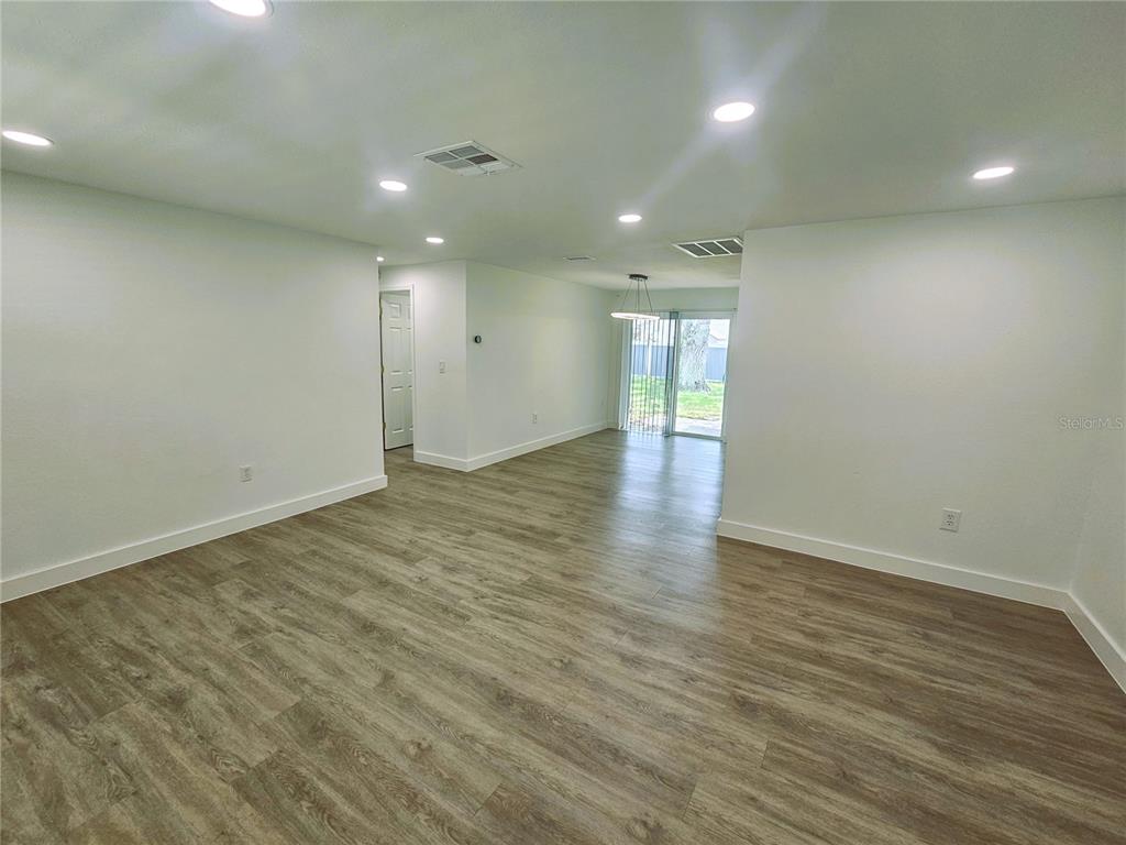 12218 Shadow Ridge Boulevard Hudson, FL 34669 - Photo 23 of 34 an empty room with wooden floor and windows