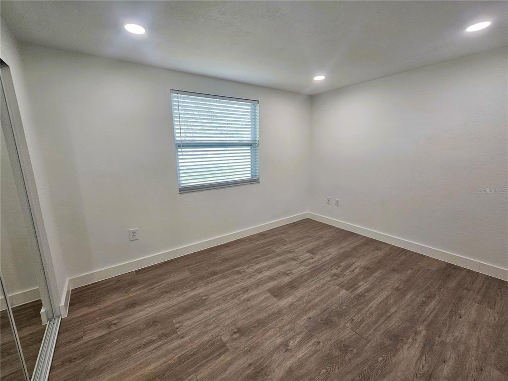 12218 Shadow Ridge Boulevard Hudson, FL 34669 - Photo 26 of 34 an empty room with wooden floor and windows
