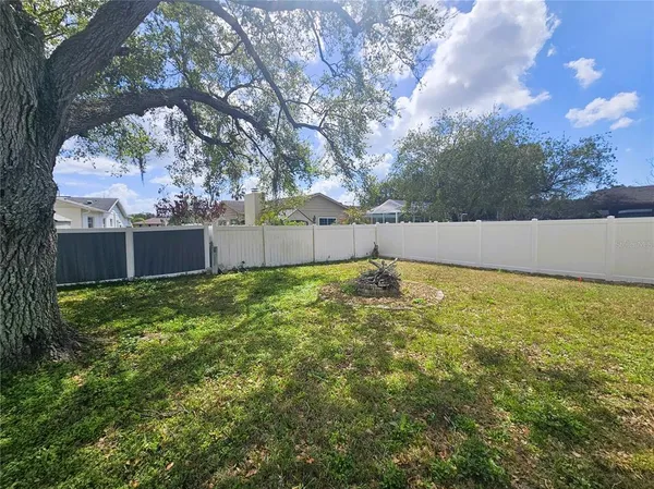 a view of backyard with a barn and large trees