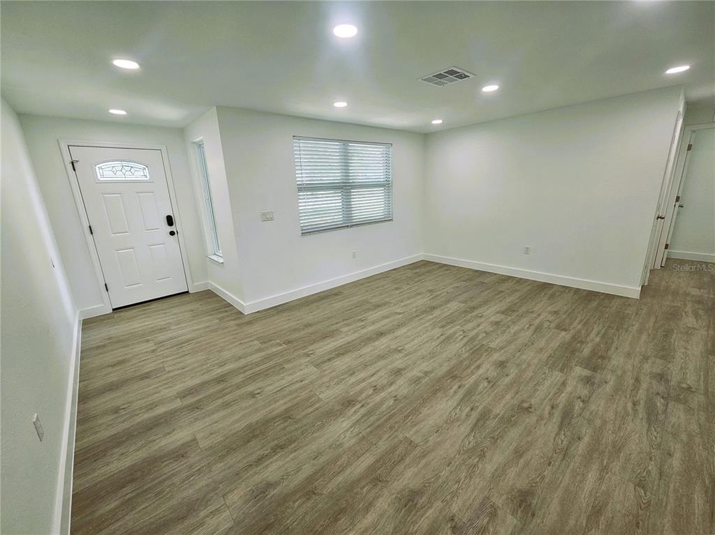 12218 Shadow Ridge Boulevard Hudson, FL 34669 - Photo 8 of 34 an empty room with wooden floor and windows