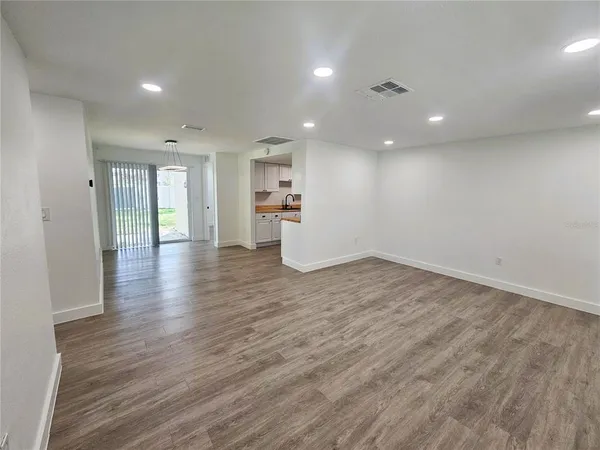 an empty room with wooden floor and window