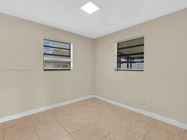 a bedroom with bed and a lamp on dresser