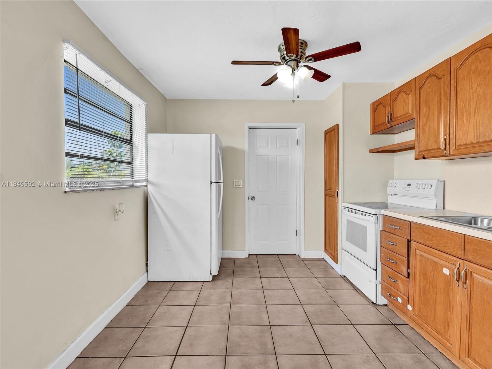 5611 Southwest 37th Street, Unit 1 Davie, FL 33314 - Photo 16 of 46 a view of a kitchen with a sink dishwasher and a refrigerator