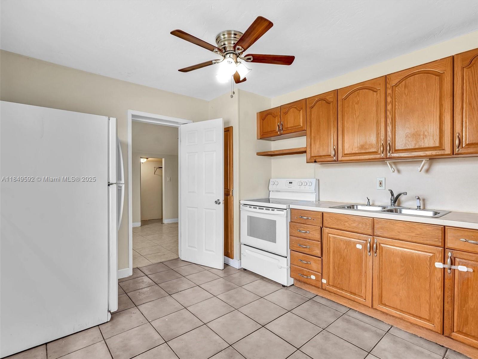 5611 Southwest 37th Street, Unit 1 Davie, FL 33314 - Photo 23 of 46 a kitchen with white cabinets and white appliances