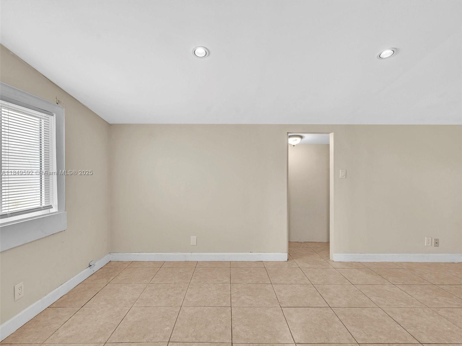 5611 Southwest 37th Street, Unit 1 Davie, FL 33314 - Photo 27 of 46 an empty room with windows and entrance to other room