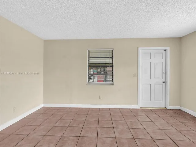 a view of an empty room with window and cabinet