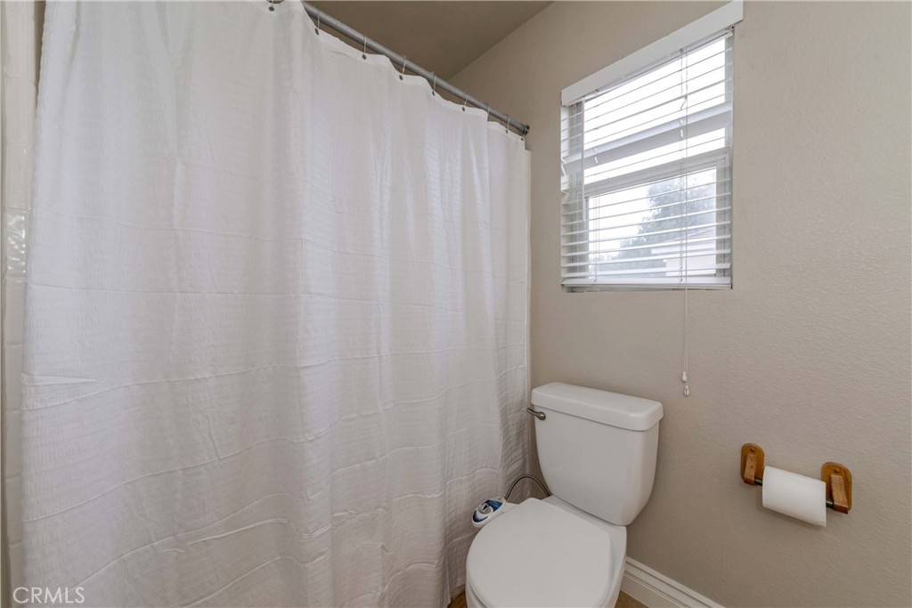 9220 Village Way Riverside, CA 92508 - Photo 43 of 73 a white toilet sitting next to a shower curtain