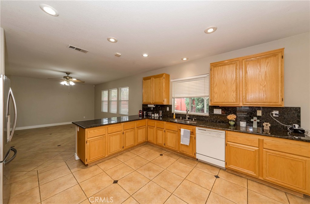 9220 Village Way Riverside, CA 92508 - Photo 7 of 73 a large kitchen with granite countertop a sink and white cabinets