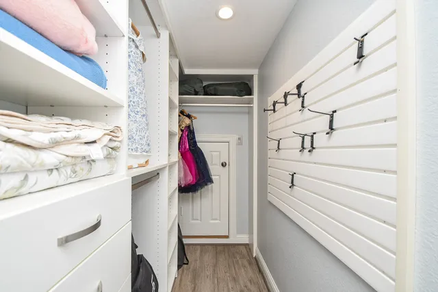 a view of walk in closet with clothes and shoes