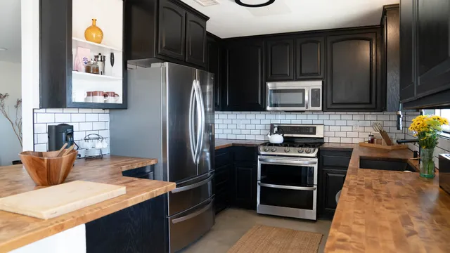 a kitchen with stainless steel appliances kitchen island granite countertop a refrigerator stove and microwave