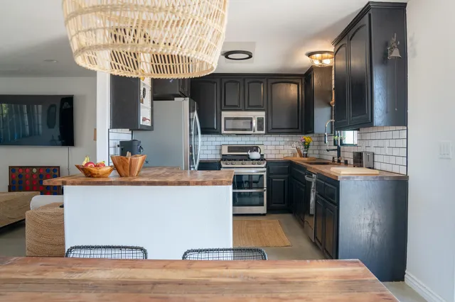 a kitchen with stainless steel appliances granite countertop a sink dishwasher stove and oven