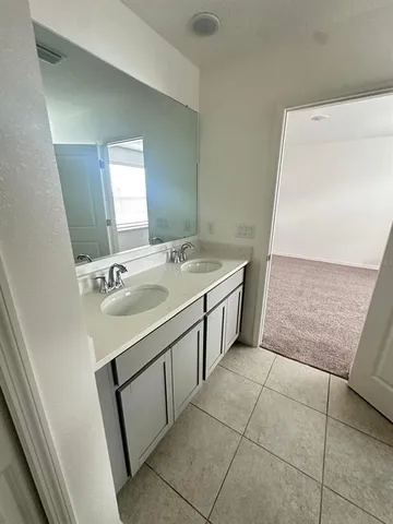 a bathroom with a double vanity sink toilet and shower