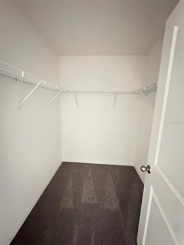 a view of a hallway with wooden floor and windows
