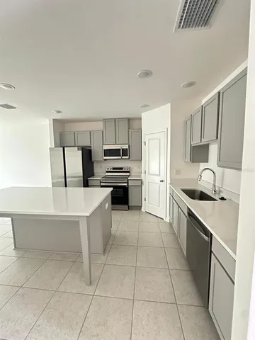 a kitchen with stainless steel appliances a refrigerator sink and cabinets