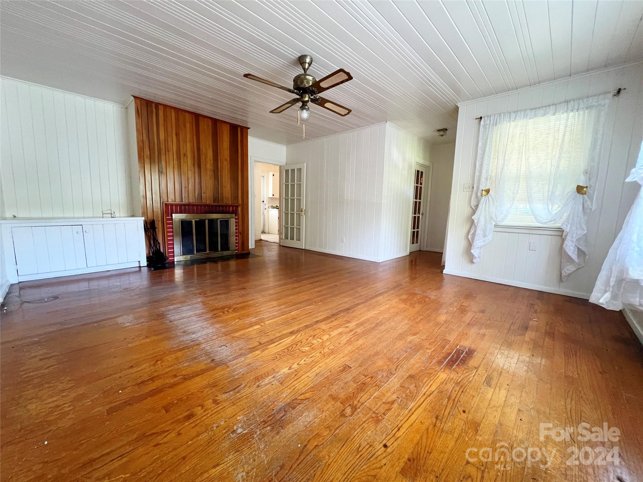 102 Steakhouse Road Morganton, NC 28655 - Photo 24 of 39 a view of a livingroom with wooden floor and a ceiling fan