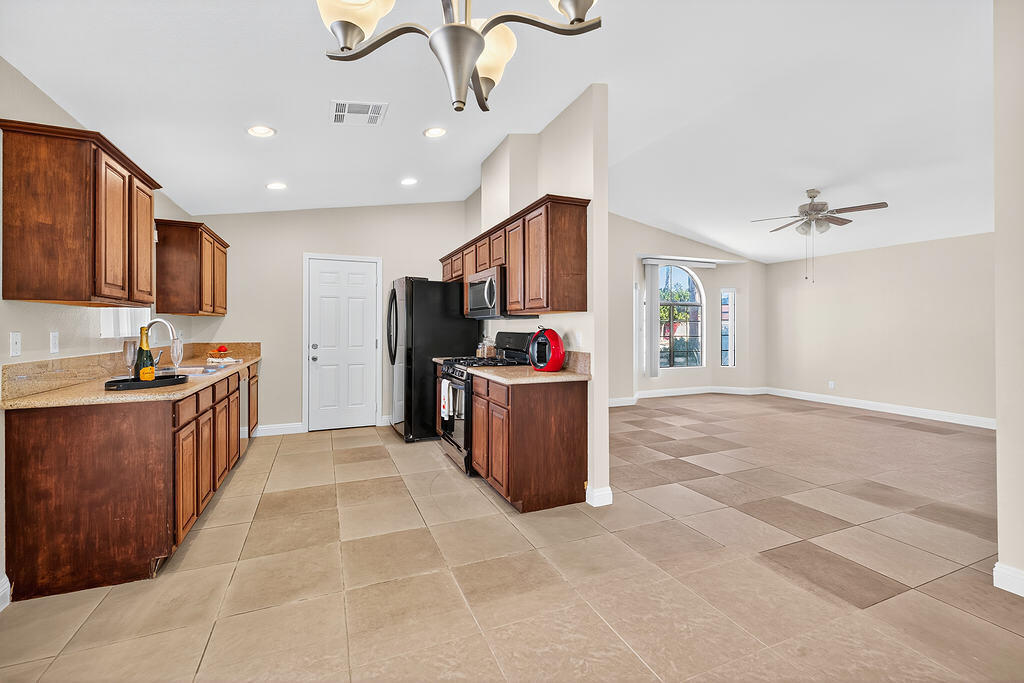 68615 Concepcion Road Cathedral City, CA 92234 - Photo 9 of 25 a kitchen with stainless steel appliances granite countertop a sink and a refrigerator