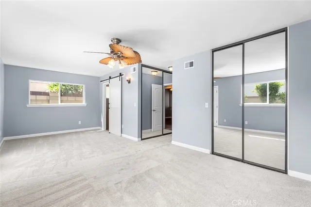 an empty room with windows and closet