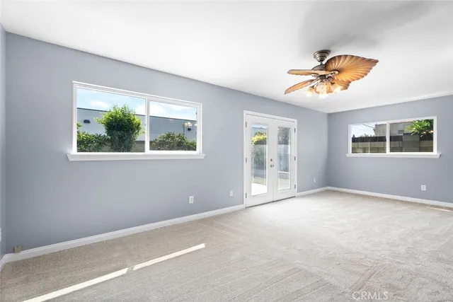 an empty room with windows and fan