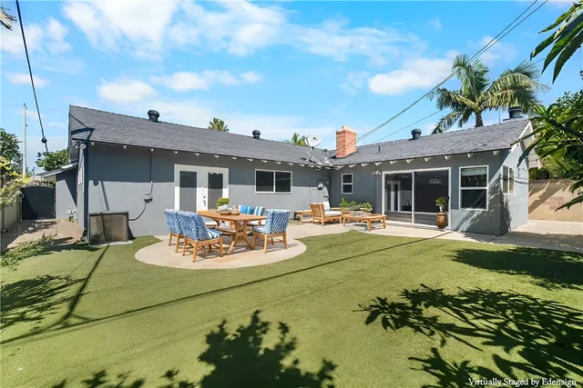 a view of a patio with table and chairs potted plants and large tree