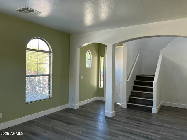 a view of a room with wooden floors and entryway