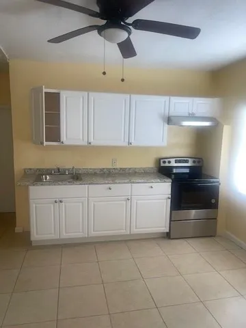 a kitchen with granite countertop a stove and cabinets
