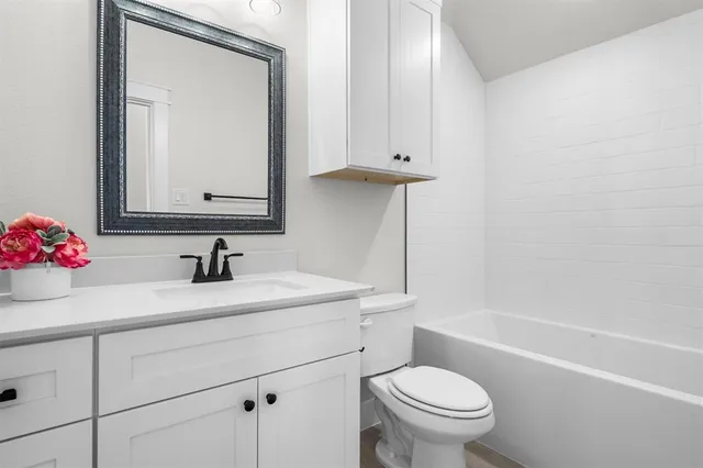 a bathroom with a sink toilet vanity and tub