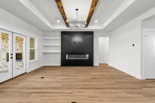 a view of an empty room with a fireplace and a window