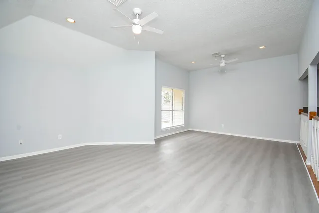 an empty room with wooden floor and window
